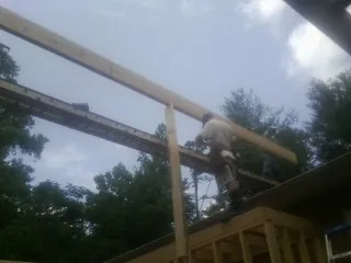 Carpenter setting a ridge beam over a new addition frame — Ice Dam Removal by Roofing Brothers in Callao