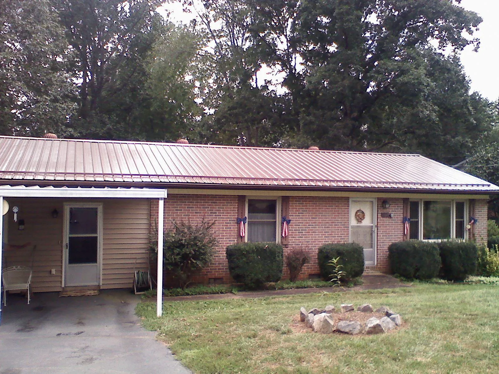 Bronze metal roof and carport on a brick ranch home — Roof Repair work by our crew in Callao